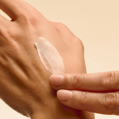 Aplicación de crema nutritiva antiedad en la mano con textura sedosa y efecto reparador - Institut Esthederm