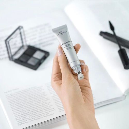 Contorno de ojos Lift & Repair de Institut Esthederm Mano sosteniendo el contorno de ojos Lift & Repair de Institut Esthederm con aplicador metálico, ideal para refrescar la mirada.