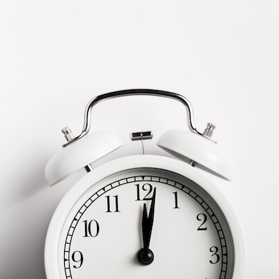 Reloj despertador marcando la medianoche, representando la importancia del ciclo circadiano en la regeneración celular.